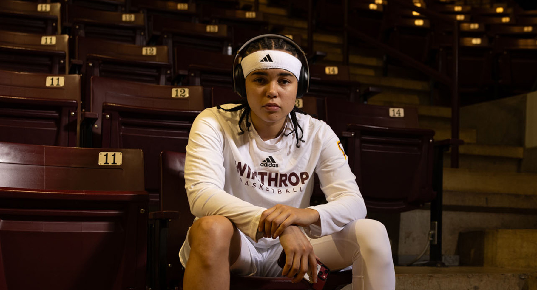 Winthrop Eagles basketball player sits on bleacher