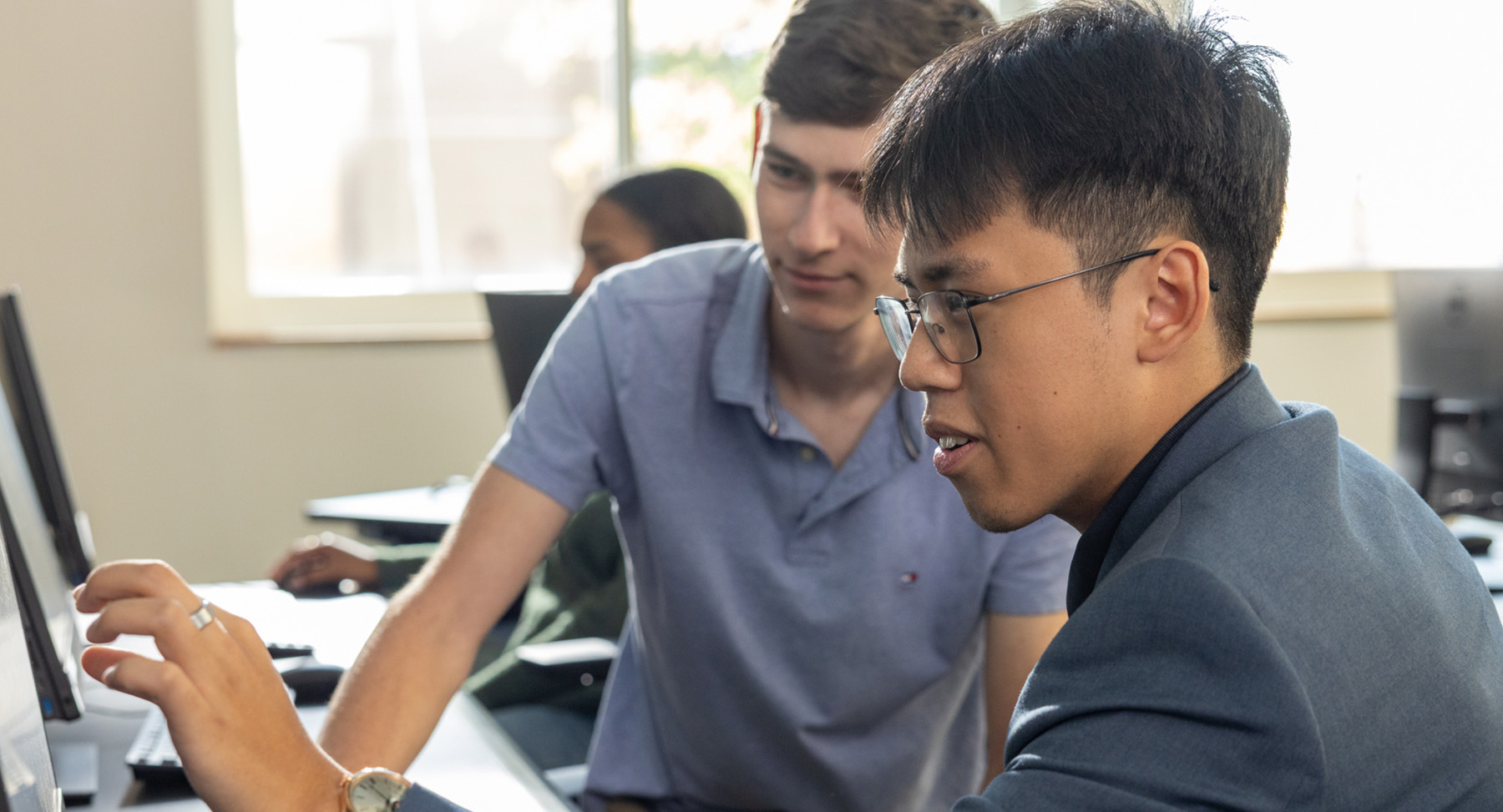 Two students looking at a computer in a computer lab