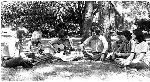 Historical photo of a group of male and female students outside