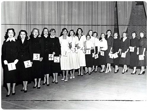 Historical photo of students lined up in different uniforms