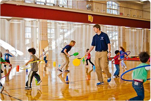 Student with kids in the gym