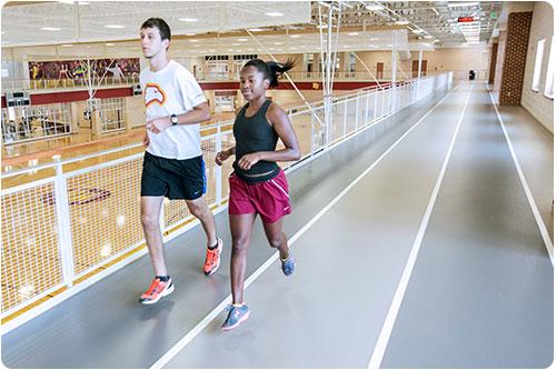 Students running on the indoor track at the West Center