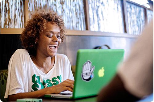 Student laughing on her laptop