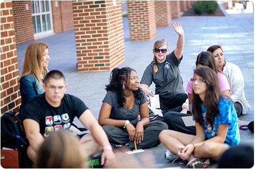Student raising her hand in outdoor class