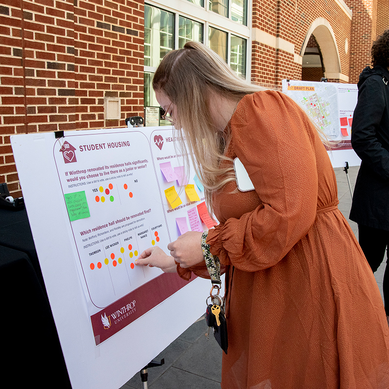 Student adding sticker to a poster