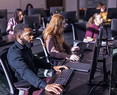 College of Business students using the computers in the Carroll Capital Markets Training
                              & Trading Center.