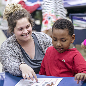 A student teacher working with a child.