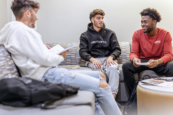 three students in a study group sitting on couches
