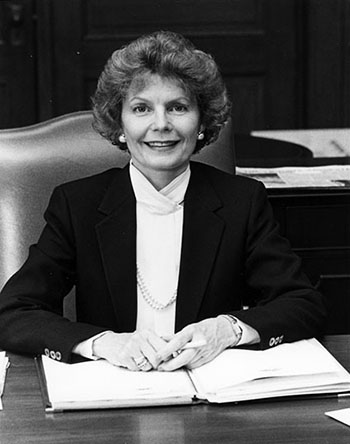 a black and white photo of Martha Kime Piper seated at her desk