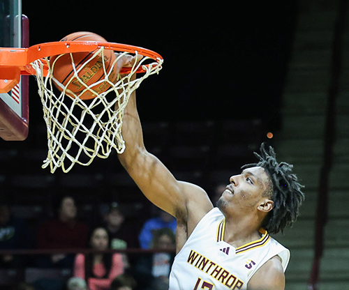 Close up shot of Men's Basketball Player KJ Doucet dunking the ball