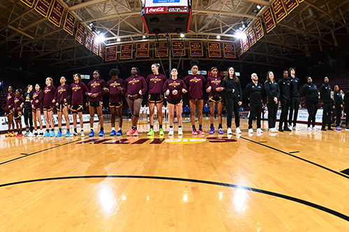 Women's basketball players in a line on the court