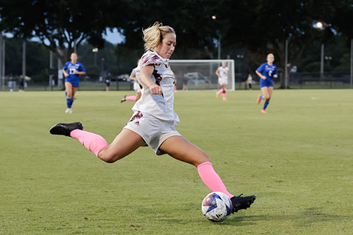 Women's Soccer player Annabel Thomas about to kick the ball