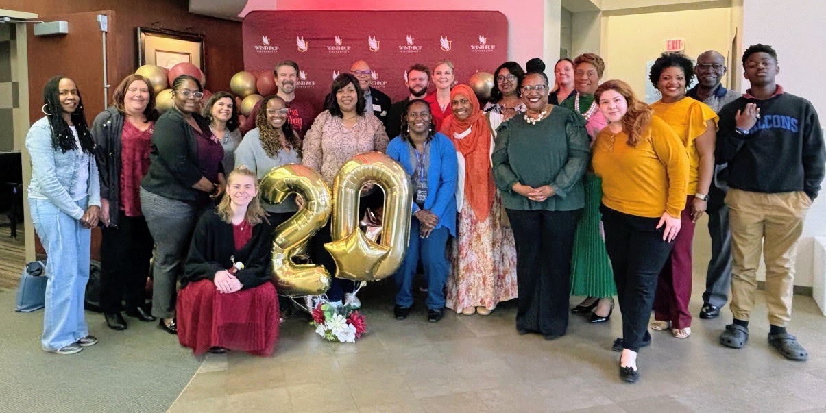 A group photo with masters of social work students and faculty celebrating 20 years
                        they have gold balloons that spell 20