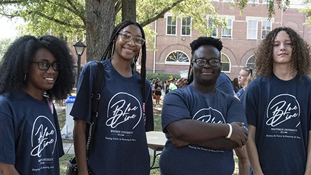 Four students wearing their blue line shirts 