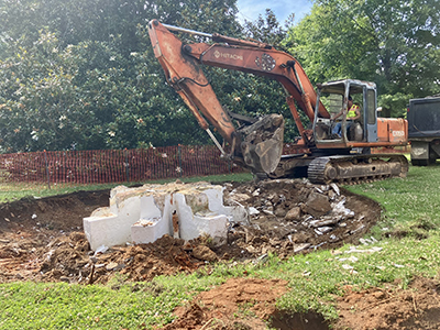 a photo of an excavator beside part of the fountain during the demolition process