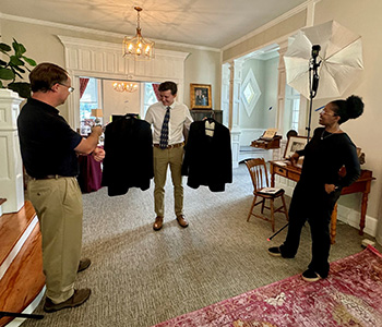 a student holding up two suit jackets