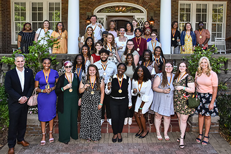 a group photo of Winthrop seniors with President Serna and the First Lady on the steps
                        of the President's House