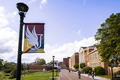 a photo of Scholars Walk with a Winthrop banner on a lamppost