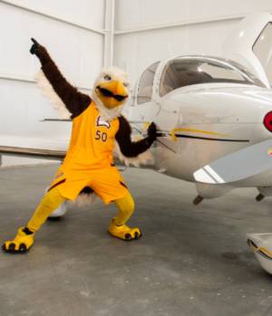 Winthrop mascot, Big Stuff, is seen posing with a small airplane.