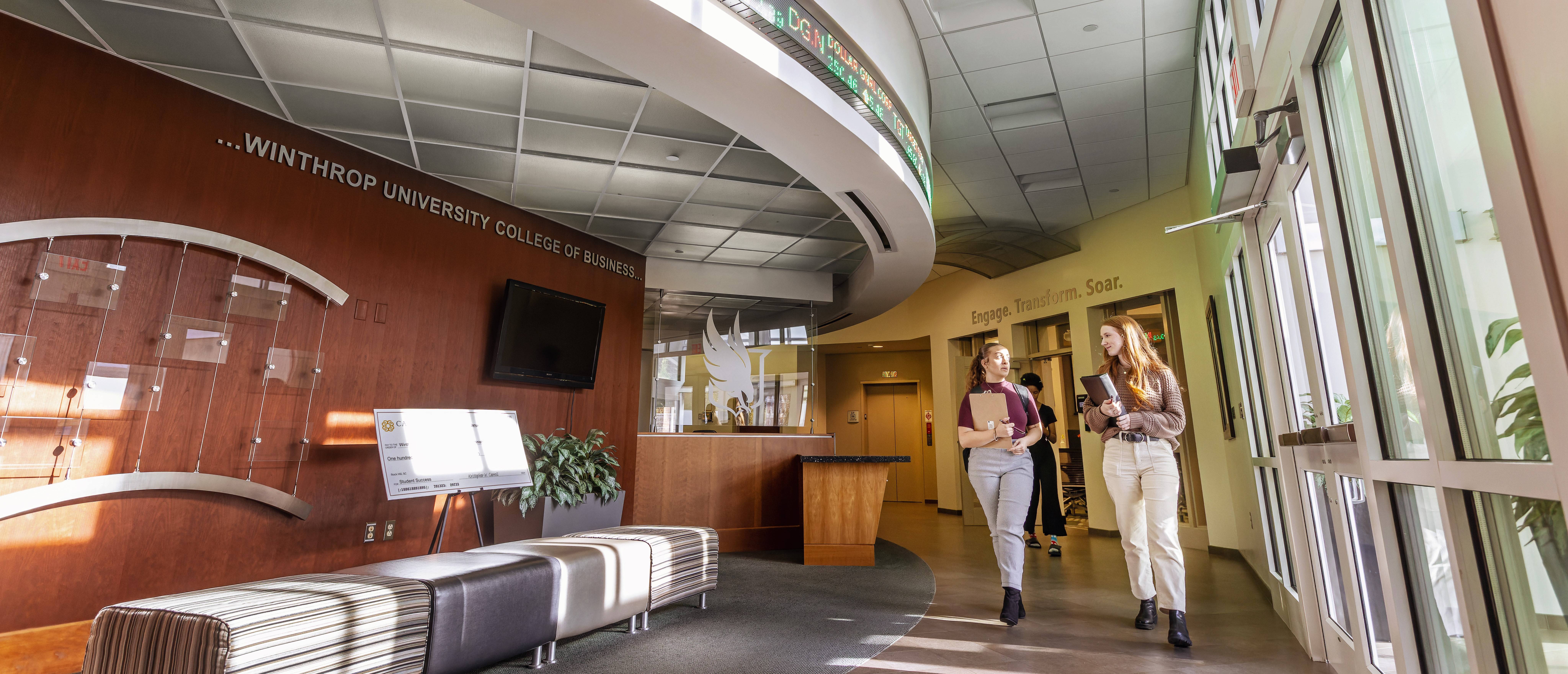 Two Students Walk in Carroll Hall
