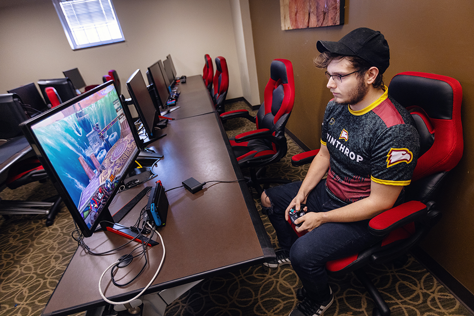 A Winthrop esports team member playing a game with a controller