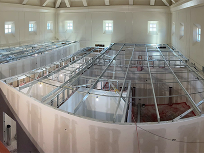 Scaffolding above ceiling in construction space.