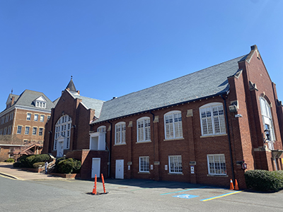 Brick building with blue sky background showing off new slate roof