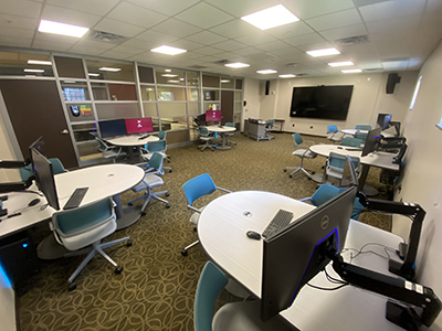 Chairs stationed around half-moon tables featuring high-tech virtual reality equipment