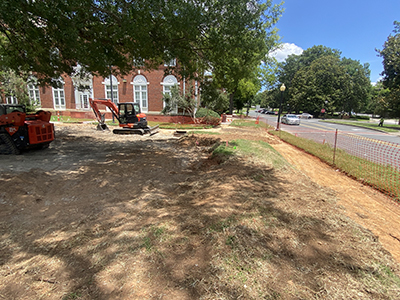 Dirt area with red construction equipment in the background