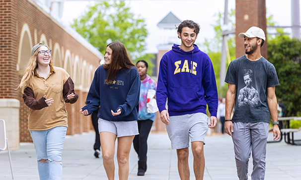 undergraduate students walking outside in front of DiGs