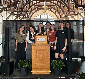 Group photo of current Honors Top Flight Ambassadors at the podium for Welcome Dinner