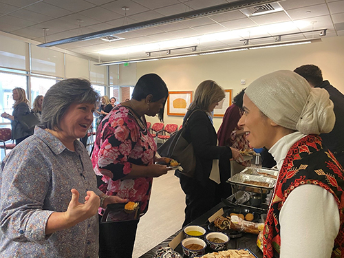 Winthrop Staff laughing while going through the buffet line at the 2023 Day of Understanding
                        luncheon