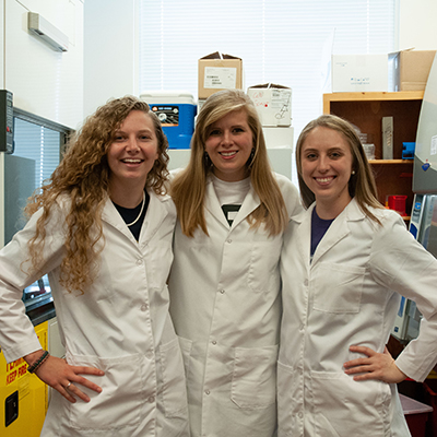 Three students in lab coats
