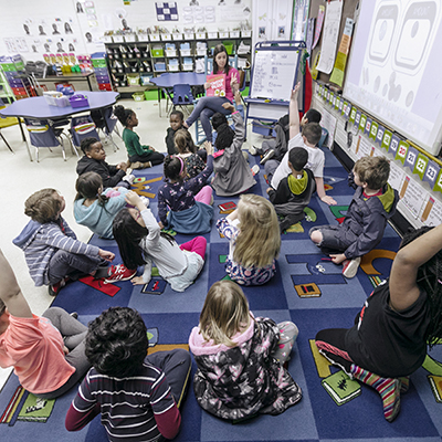 A student teacher reading to a classroom of kids
