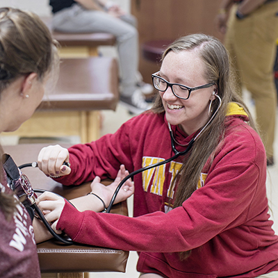Athletic training student taking someone's blood pressure