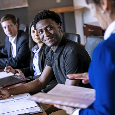 Student smiling while listening to professor's lecture