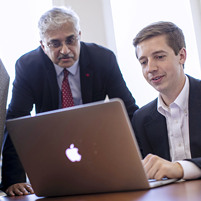Professor and student working on a laptop together