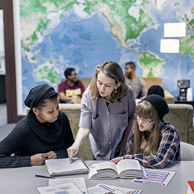 students reading in front of a world map