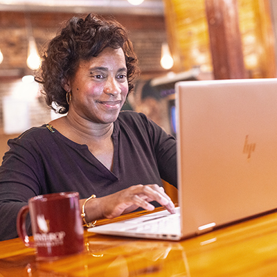 Woman smiling while working on a laptop