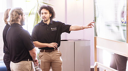 someone giving a presentation and pointing at a poster