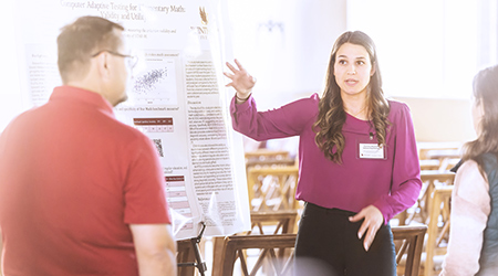 a woman giving a poster presentation
