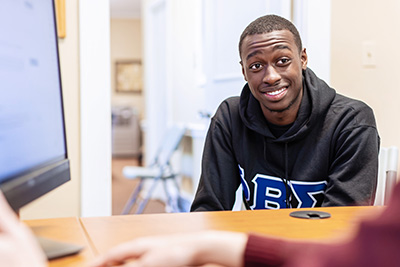 a smiling student with a laptop