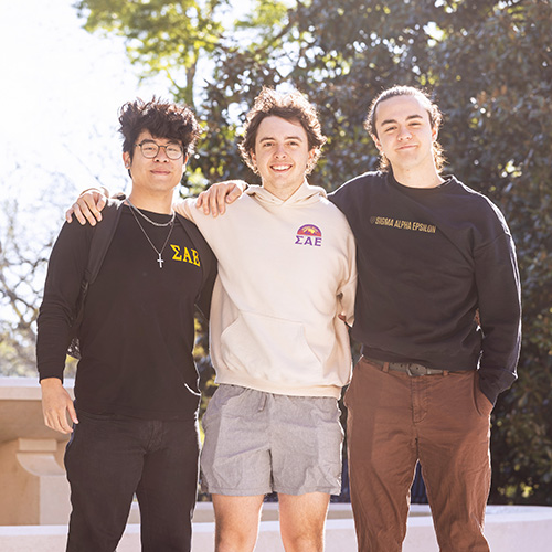 three fraternity members standing together in front of the Winthrop fountain