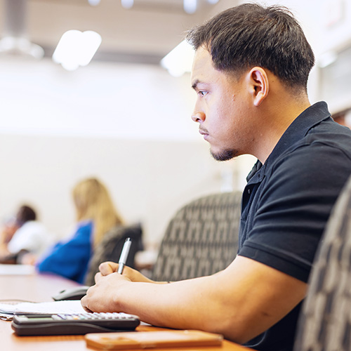 a student taking a math exam with a calculator at a computer