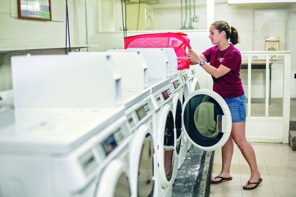Student using a residence hall laundry machine