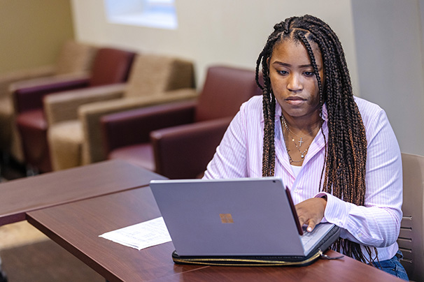 an adult student doing coursework on their laptop