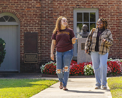 two students walking by the Little Chapel on Winthrop's campus