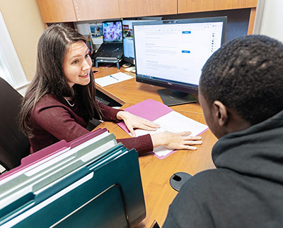 a financial aid counselor meeting with a student in her office
