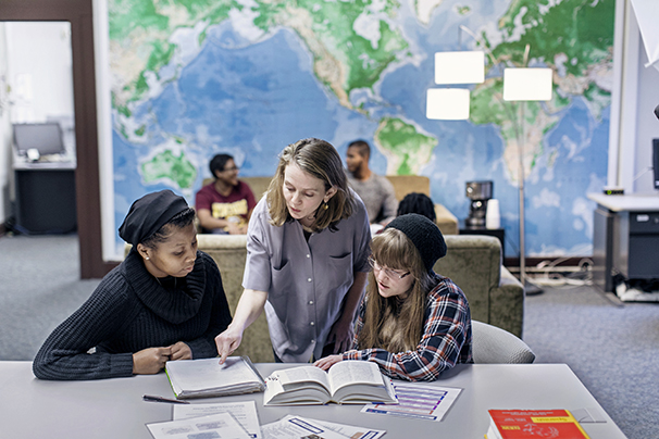 a professor talking to two students in the language lab