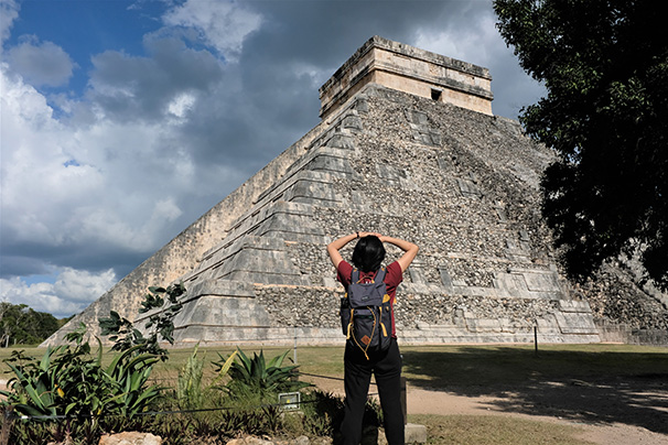 a student standing in front of Chichen Itza